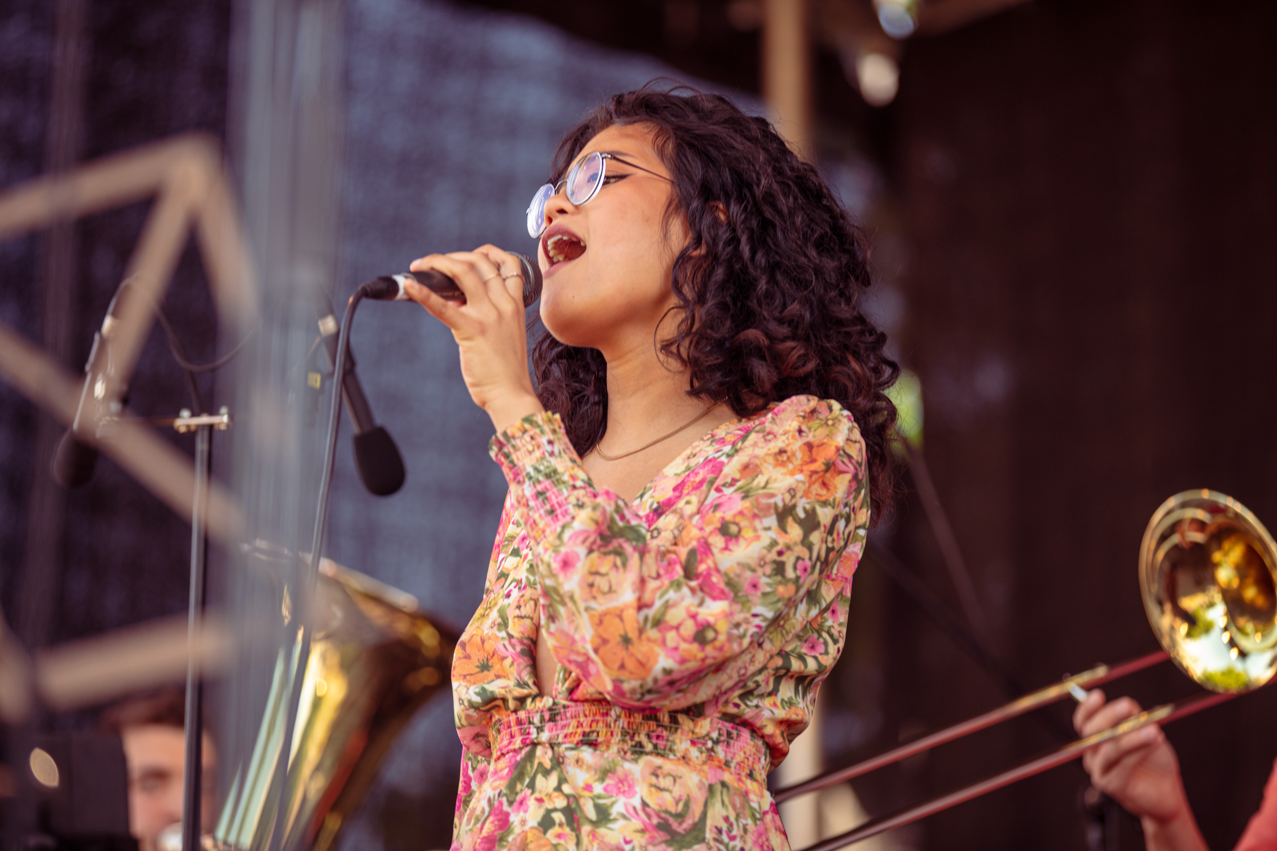 Kezia Editha Christy singt auf der Bühne in einem Sommerkleid