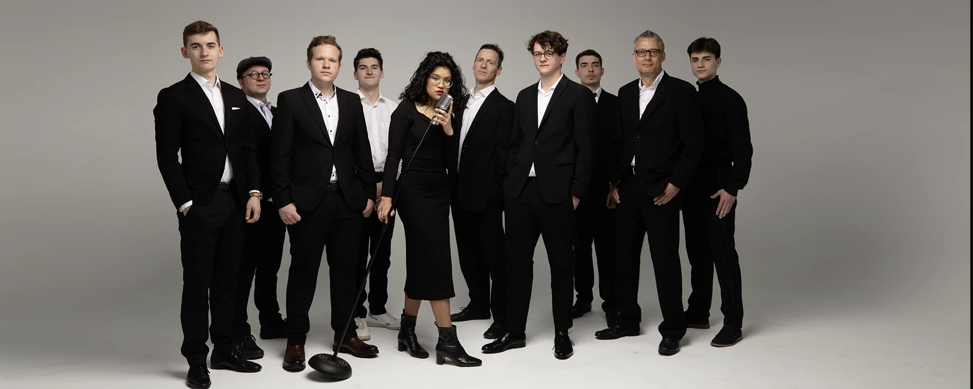 Die Bandmitglieder im klassischen Outfit mit schwarzen Smoking und Cocktailkleid